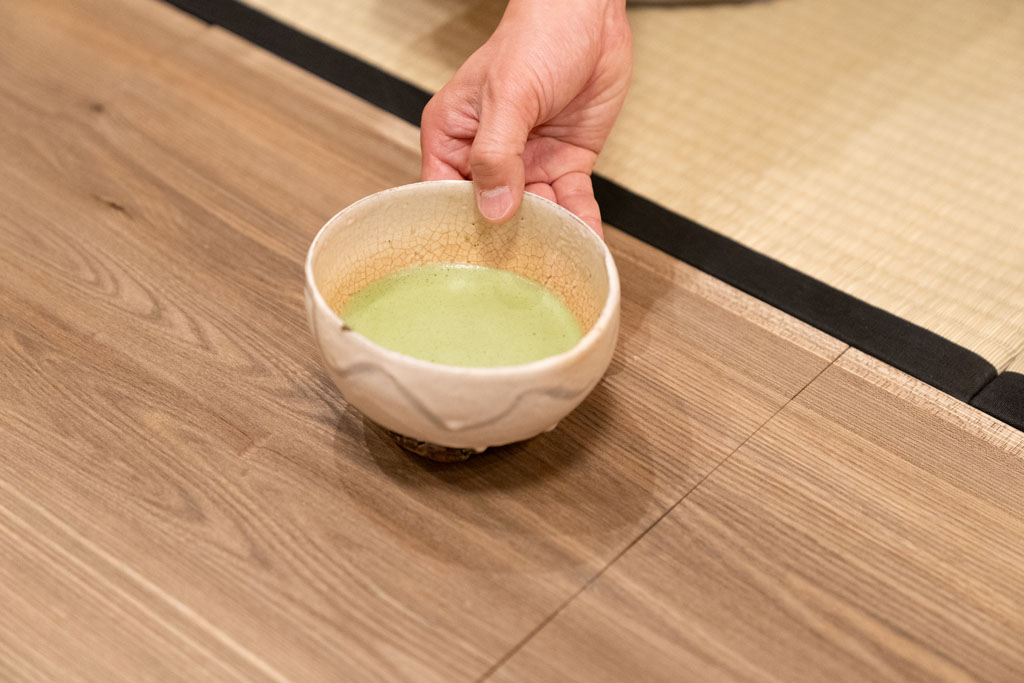 川喜田半泥子の作った茶碗。高台に、焼くときに茶碗を持った指の跡が付いている。「箱書きは半泥子のお孫さんが『唐津風 白がけ波状文 灰釉（草木の灰を原料にした釉薬）茶碗』と書いています」（朝倉氏）