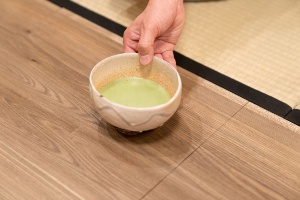 川喜田半泥子の作った茶碗。高台に、焼くときに茶碗を持った指の跡が付いている。「箱書きは半泥子のお孫さんが『唐津風 白がけ波状文 灰釉(草木の灰を原料にした釉薬)茶碗』と書いています」(朝倉氏)