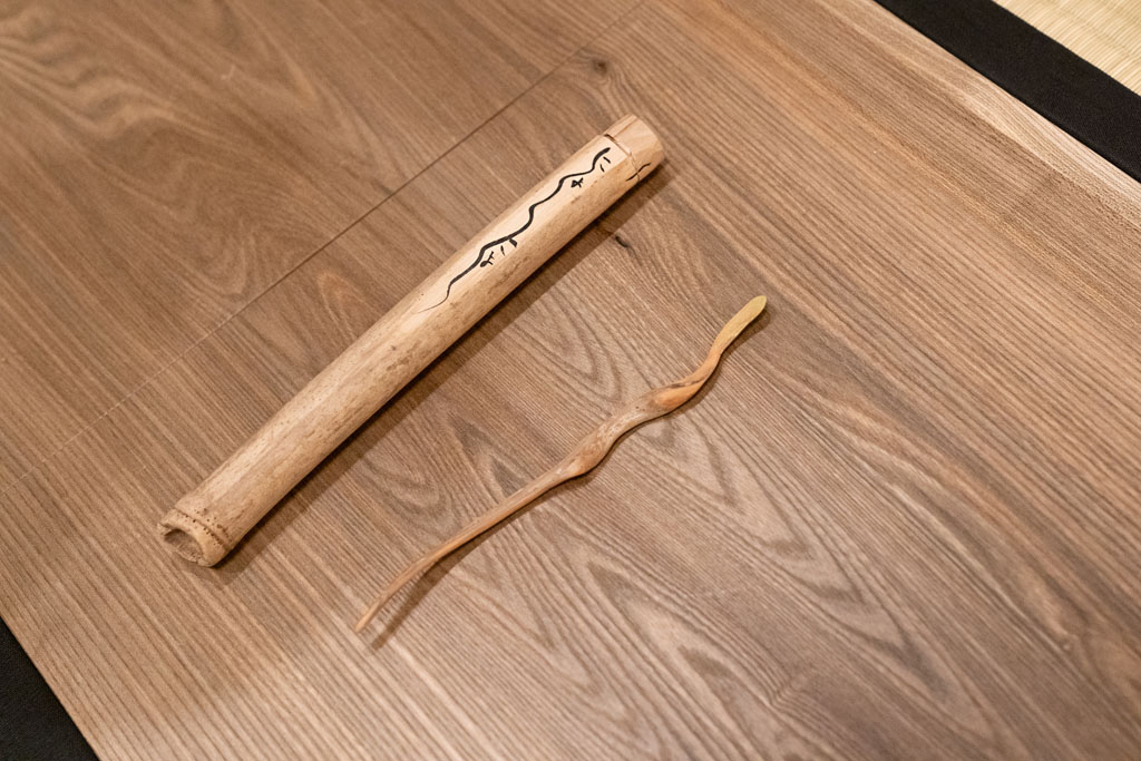 流木から自作した茶杓(右)。銘を「にょろにょろ」と付けた。入れる筒(左)も朝倉氏の自作