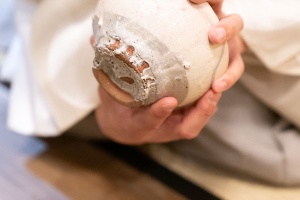 川喜田半泥子の作った茶碗。高台に、焼くときに茶碗を持った指の跡が付いている。「箱書きは半泥子のお孫さんが『唐津風 白がけ波状文 灰釉(草木の灰を原料にした釉薬)茶碗』と書いています」(朝倉氏)