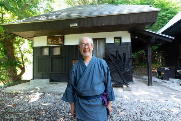 南総学舎の敷地内にある茶室「哲心庵」の前で、作務衣(さむえ)姿の大滝氏。自ら設計・改装した四畳半の茶室で、リーダー研修やコーチングの場としても活用されている