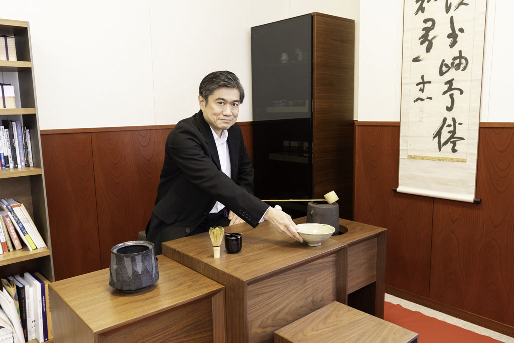 学長室に立礼（りゅうれい）のテーブルを設置。茶道具を置き、出校した際は、ほぼ毎回点前をしている。右側に見える掛軸は、哲学者の西田幾多郎が揮毫（きごう）したもの