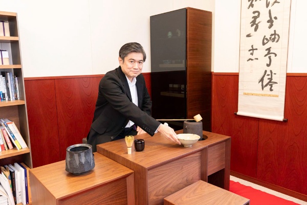 学長室に立礼(りゅうれい)のテーブルを設置。茶道具を置き、出校した際は、ほぼ毎回点前をしている。右側に見える掛軸は、哲学者の西田幾多郎が揮毫(きごう)したもの