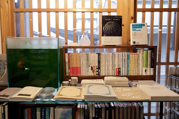 金魚の水槽の横には宮沢賢治をはじめ、独自にセレクトした本や雑貨が並ぶ
