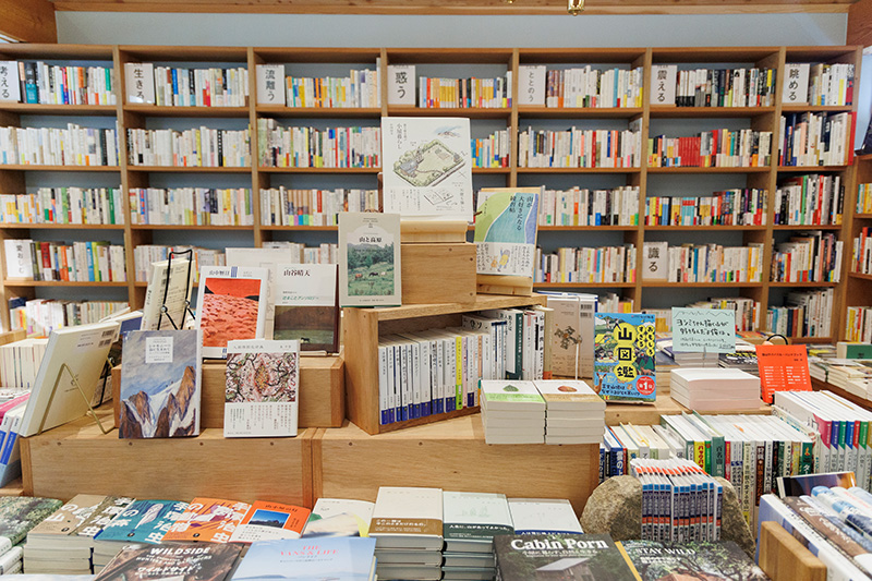 中央の平台には登山地図、登山ガイド、山小屋、キャンプ、温泉関連、ヤマケイ文庫など、山暮らしの本屋らしいラインアップがそろう