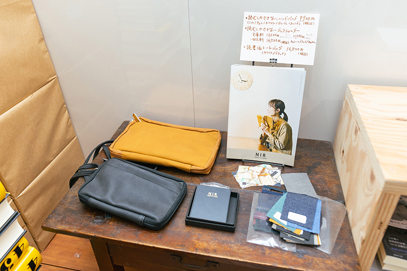 「読むしかできないハンドバッグ」と「読むしかできないブックショルダー」（左）。読書家のためのバッグ類を販売している
