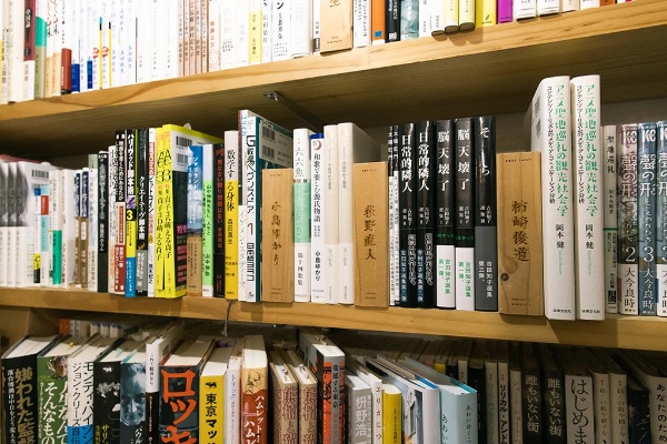 木札に選書者の名前が刻まれた選書コーナー。新刊も古本も交じっている 木札に選書者の名前が刻まれた選書コーナー。新刊も古本も交じっている