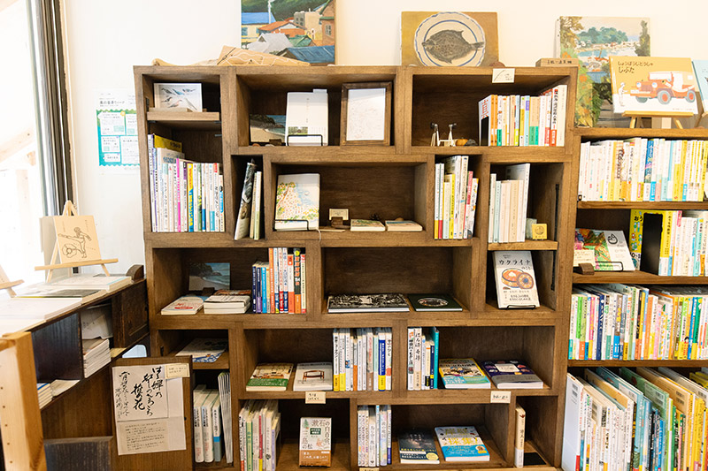 真鶴を訪れた人に役立つ本を集めた棚。『神秘的で美しい石図鑑』（ナツメ社）、『こどもが探せる身近な場所の　きれいな石材図鑑』（創元社）、『三つの石で地球がわかる』（講談社ブルーバックス）など石関連の本もそろう