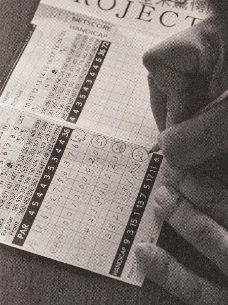 尾林プロの「3分割記入法」。1枚のスコアカードに合計打数とペナルティ数、SG数(ショートゲーム打数)とショット数を書く。4人のスコア記入の欄にこれらを書くことで自分の課題が明確になる(写真:書斎のゴルフ) 尾林プロの「3分割記入法」。1枚のスコアカードに合計打数とペナルティ数、SG数(ショートゲーム打数)とショット数を書く。4人のスコア記入の欄にこれらを書くことで自分の課題が明確になる(写真:書斎のゴルフ)