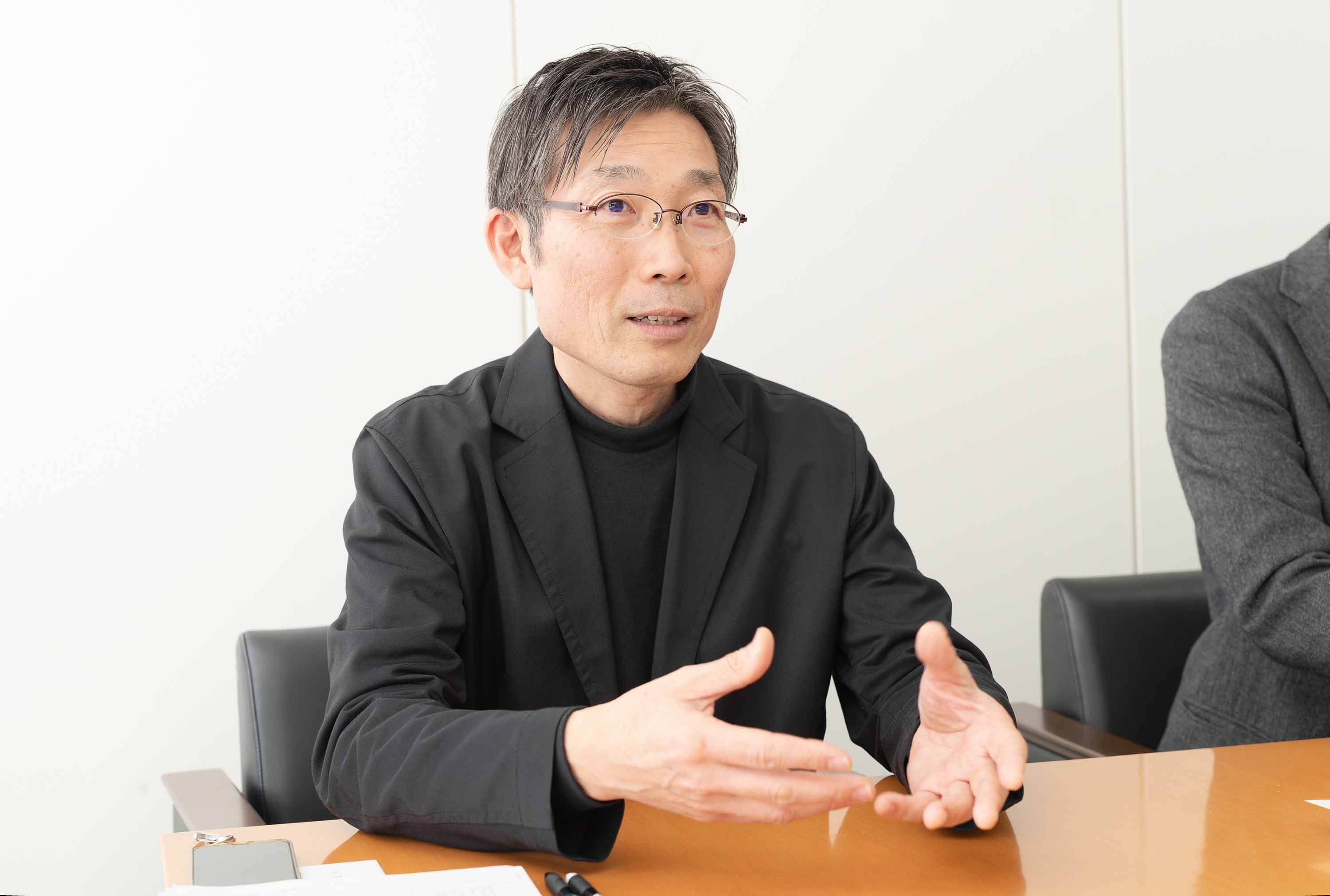 小学4年生の藤井少年がリラックスできるように将棋盤の横に寝そべるポーズを提案したという小園雅之さん