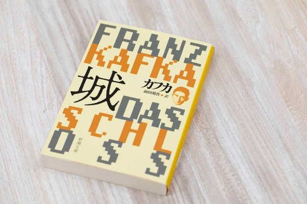 カフカが最晩年に執筆した未完の小説。測量技師の「K」は雇われた古城に到着するもいつまで経っても入れてもらえず、城下町の住民たちに翻弄される。『K+ICO』ではUber Eatsの配達員の「K」が、カフカの『城』をオーディオブックで毎日聴きながら配達に勤しむ様子が描かれる(撮影:小野さやか)