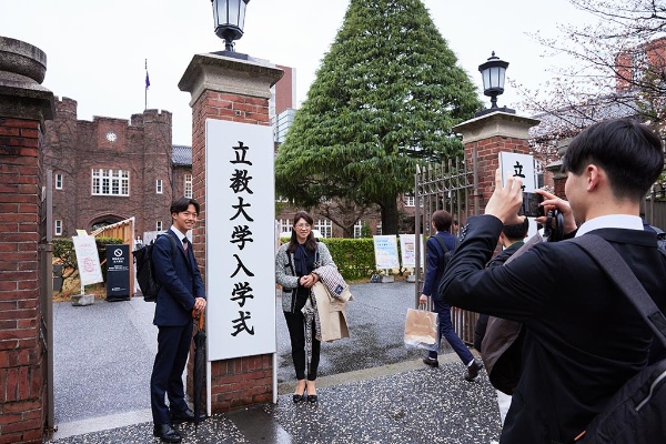 入学式の大学正門で記念撮影をする学生ら(立教大学池袋キャンパス)(写真:立教大学提供) 入学式の大学正門で記念撮影をする学生ら(立教大学池袋キャンパス)(写真:立教大学提供)