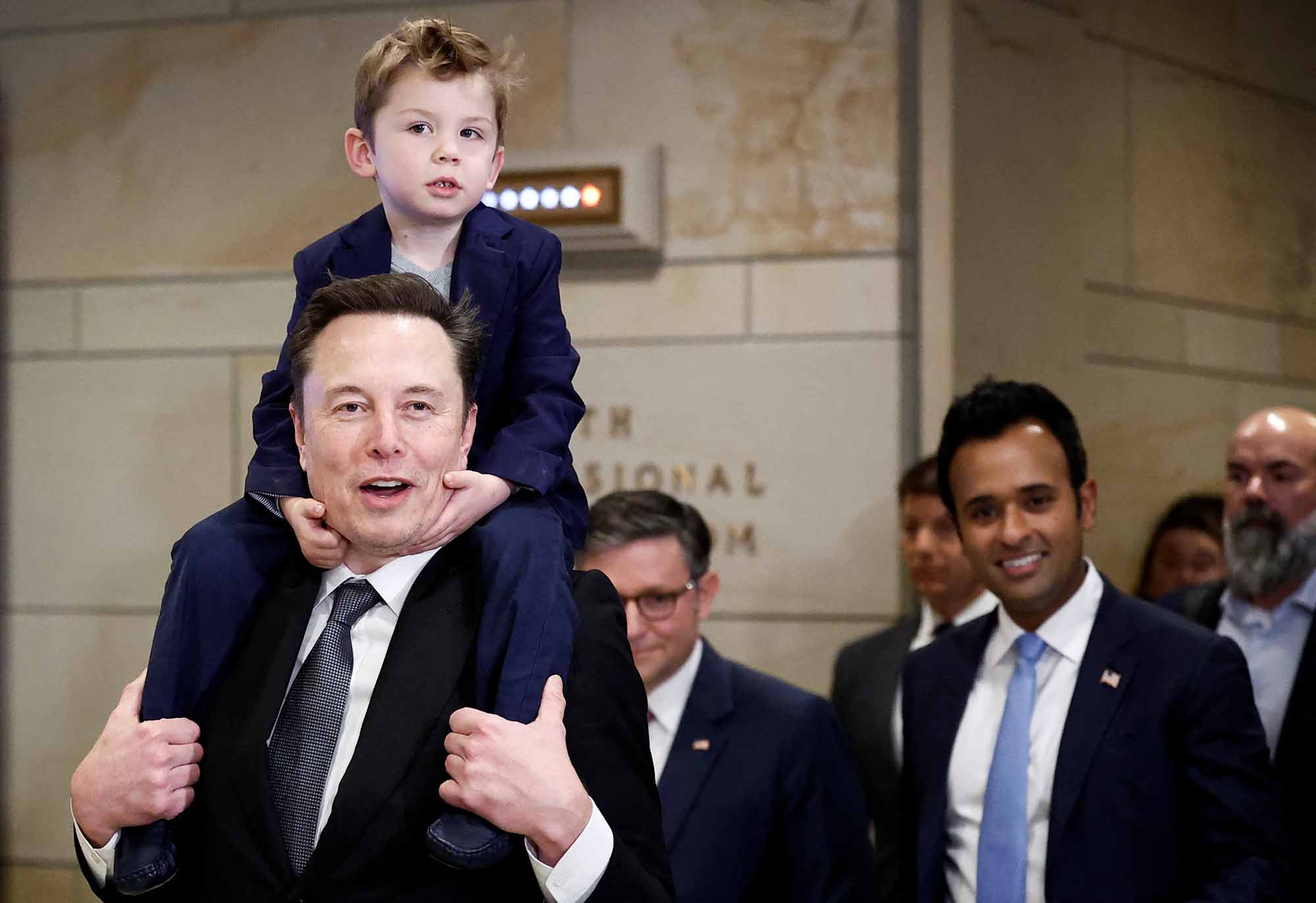 トランプ政権で「政府効率化省（DOGE）」を率いるイーロン・マスクとビベック・ラマスワミ（水色のネクタイの男性）。共にリバタリアンだ（写真＝ロイター／アフロ）