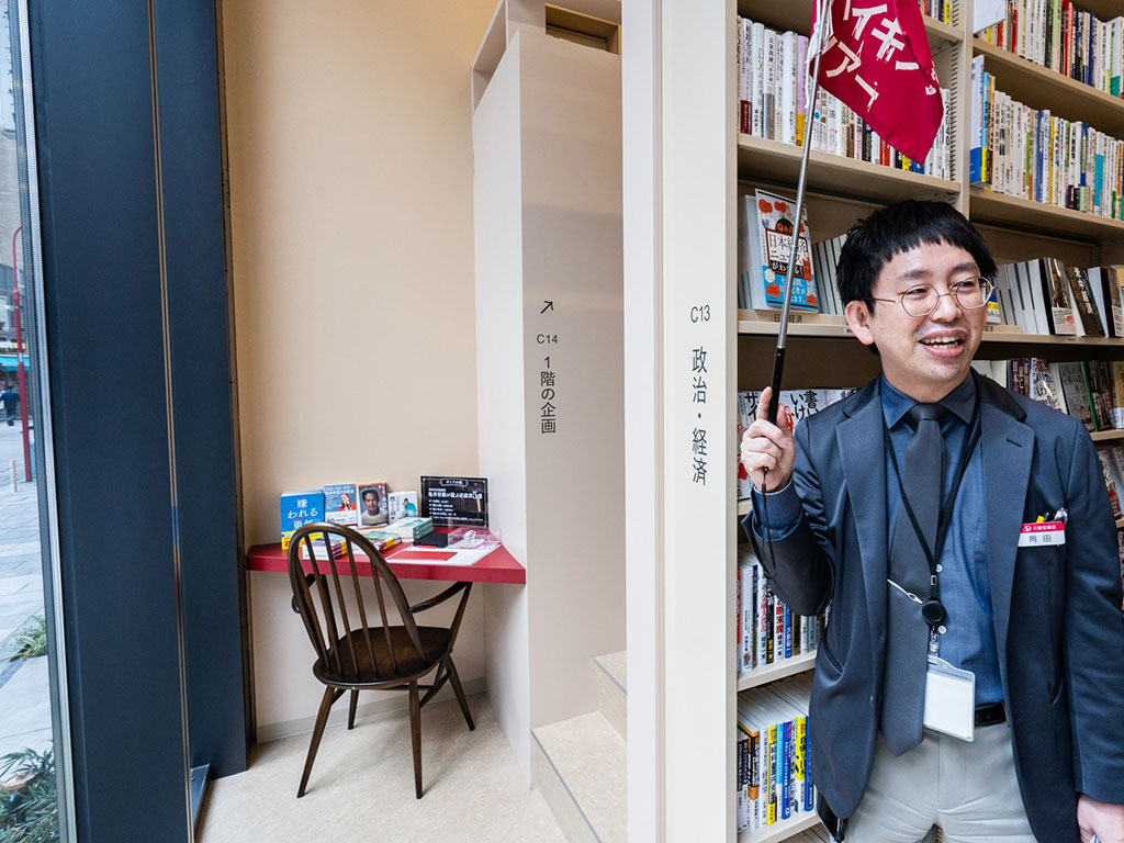 「1階の奥に設けられた、著名人お薦めの必読書を紹介する「ガイドの机」。見つけたらうれしい隠れスポット」と紹介する岡田副本店長