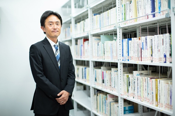 日本総合研究所 マクロ経済研究センターにある書庫に立つ西岡慎一さん 日本総合研究所 マクロ経済研究センターにある書庫に立つ西岡慎一さん