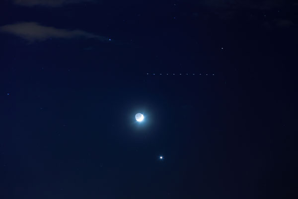 三日月と金星をバックに夜空を走る「スターリンクトレイン」（写真：dmf87／stock.adobe.com）