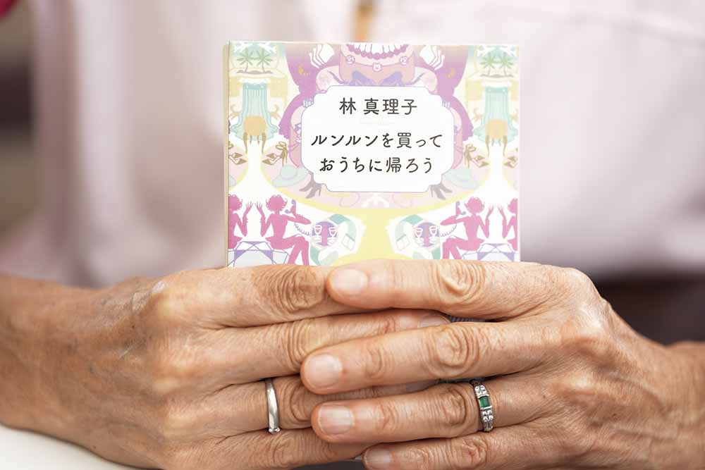 『ルンルンを買っておうちに帰ろう』（林真理子著、角川文庫）／画像クリックでAmazonページへ<br>1982年刊行、林真理子のデビュー作。ブランド品への欲望や恋愛への本音、容姿へのこだわりなど、当時の女性が口にしにくかった感情を率直でユーモアあふれる筆致で綴った。飾らない語り口が多くの読者の共感を呼んだ。弓削田さんは教員2年目の夏、現実逃避に訪れた京都の書店で偶然この本を手に取った。