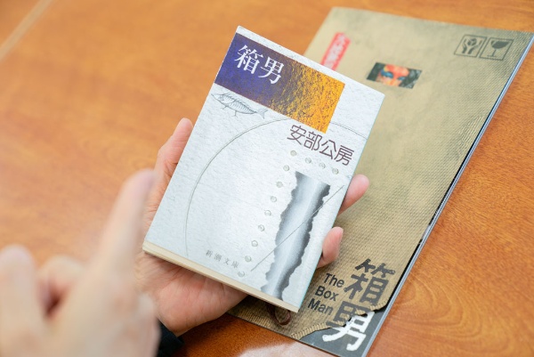 「『箱男』(安部公房著/新潮文庫)は、他者との関係や『自分とは何か』という問いを根底から揺さぶる作品です。大学時代に読んだときの衝撃は、今も忘れられません」(後ろにあるのは、映画『箱男』のパンフレット) 「『箱男』(安部公房著/新潮文庫)は、他者との関係や『自分とは何か』という問いを根底から揺さぶる作品です。大学時代に読んだときの衝撃は、今も忘れられません」(後ろにあるのは、映画『箱男』のパンフレット)