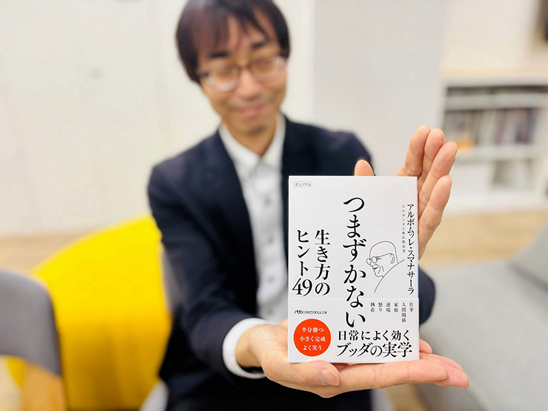 『つまずかない　生き方のヒント49（日経ビジネス人文庫）』（アルボムッレ・スマナサーラ著）。そっと目を閉じ、とても穏やかな表情で、静かに本書をお薦めしております