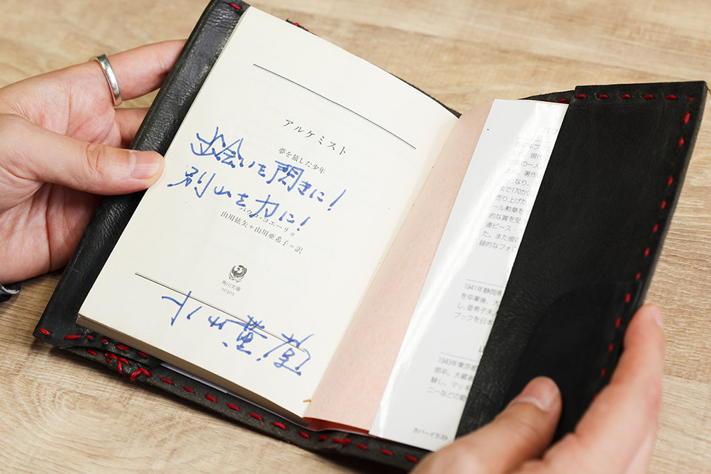 みんなで手作りしてくれたブックカバーの中には、小山薫堂さんのメッセージ入りの書籍『アルケミスト』が入っている